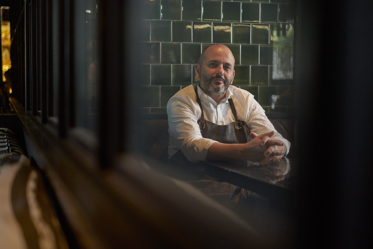 Chef head shot relaxing on sofa in restaurant lounge.