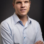 Executive team member portrait dressed in business casual.