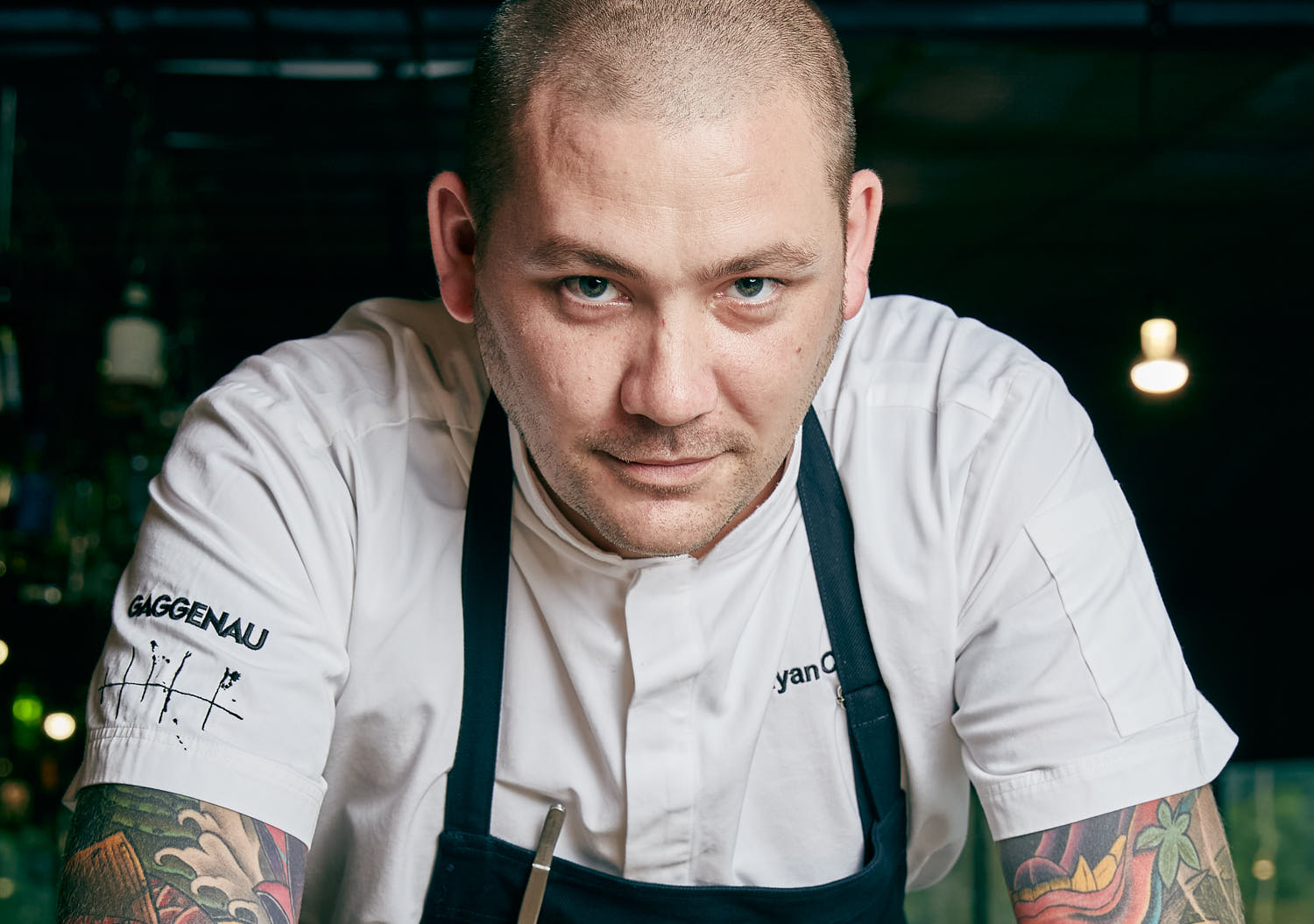 

Gourmet chef smiling in restaurant kitchen.
