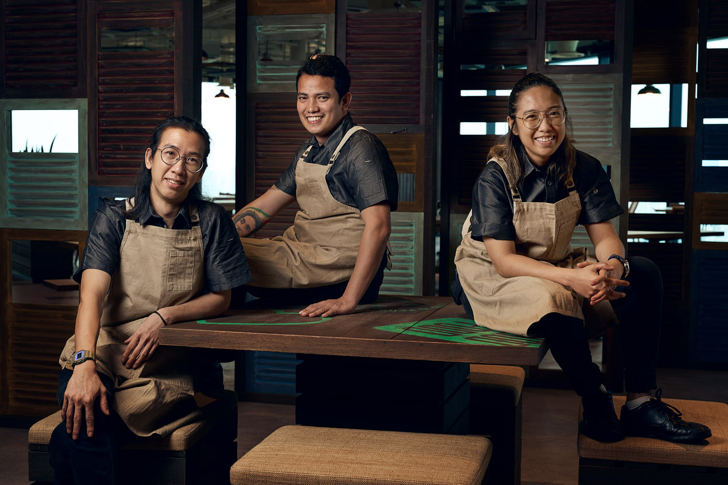 Cheerful barista team posing in coffee shop.