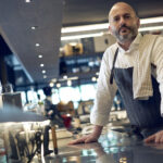 Chef in restaurant kitchen preparing dishes.