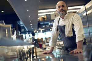 Chef in restaurant kitchen preparing dishes.
