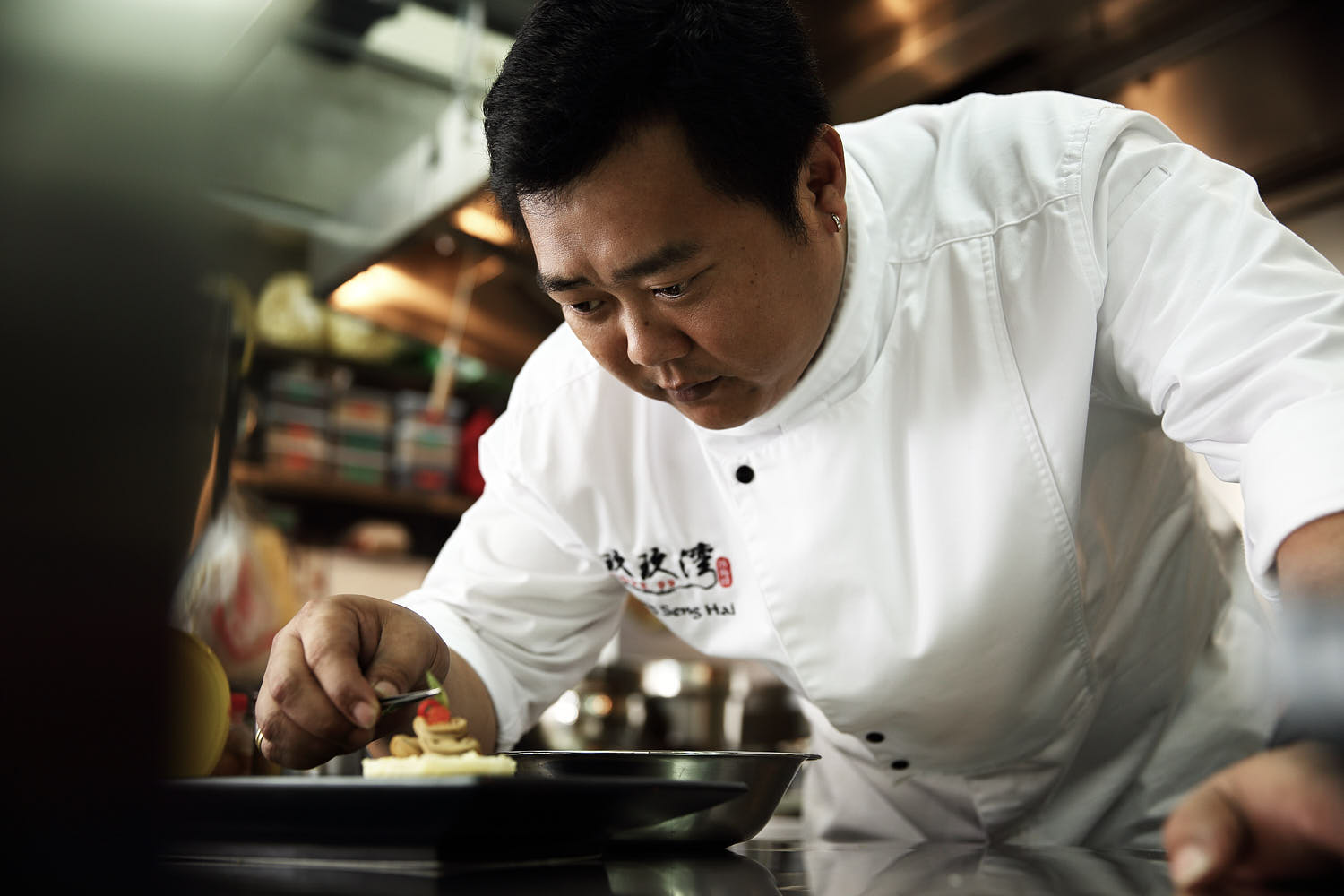 Professional chef holding kitchen tools for culinary portrait.