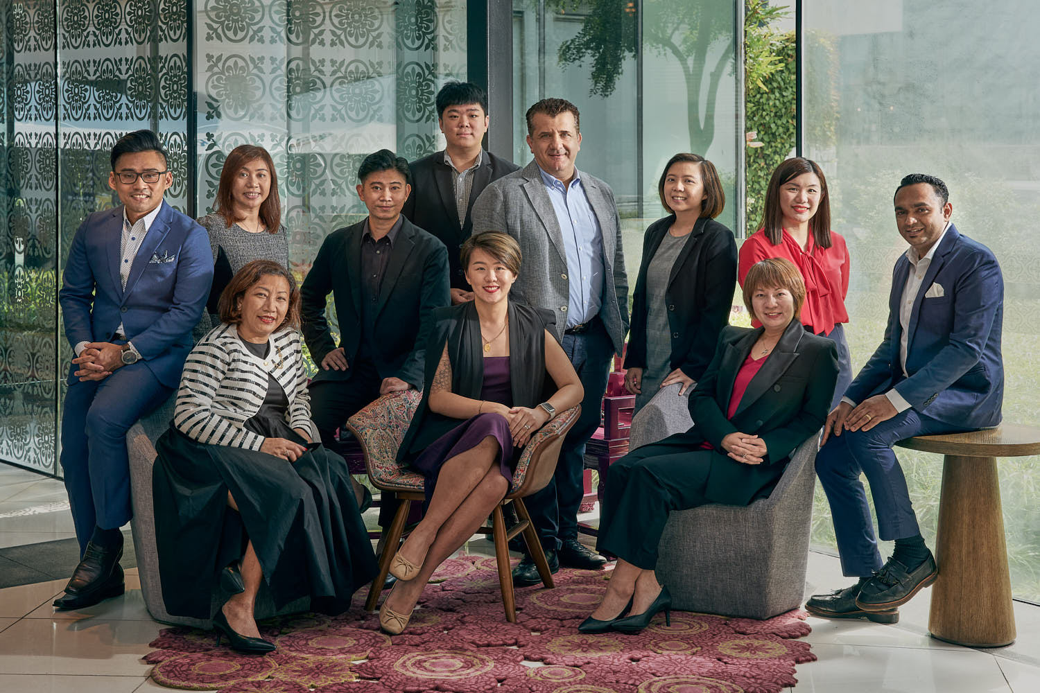 Group portrait of hotel managers at hotel entrance.