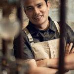 Smiling barista portrait in coffee shop.
