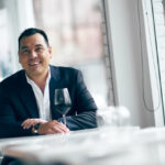 Confident executive man smiling in restaurant setting.