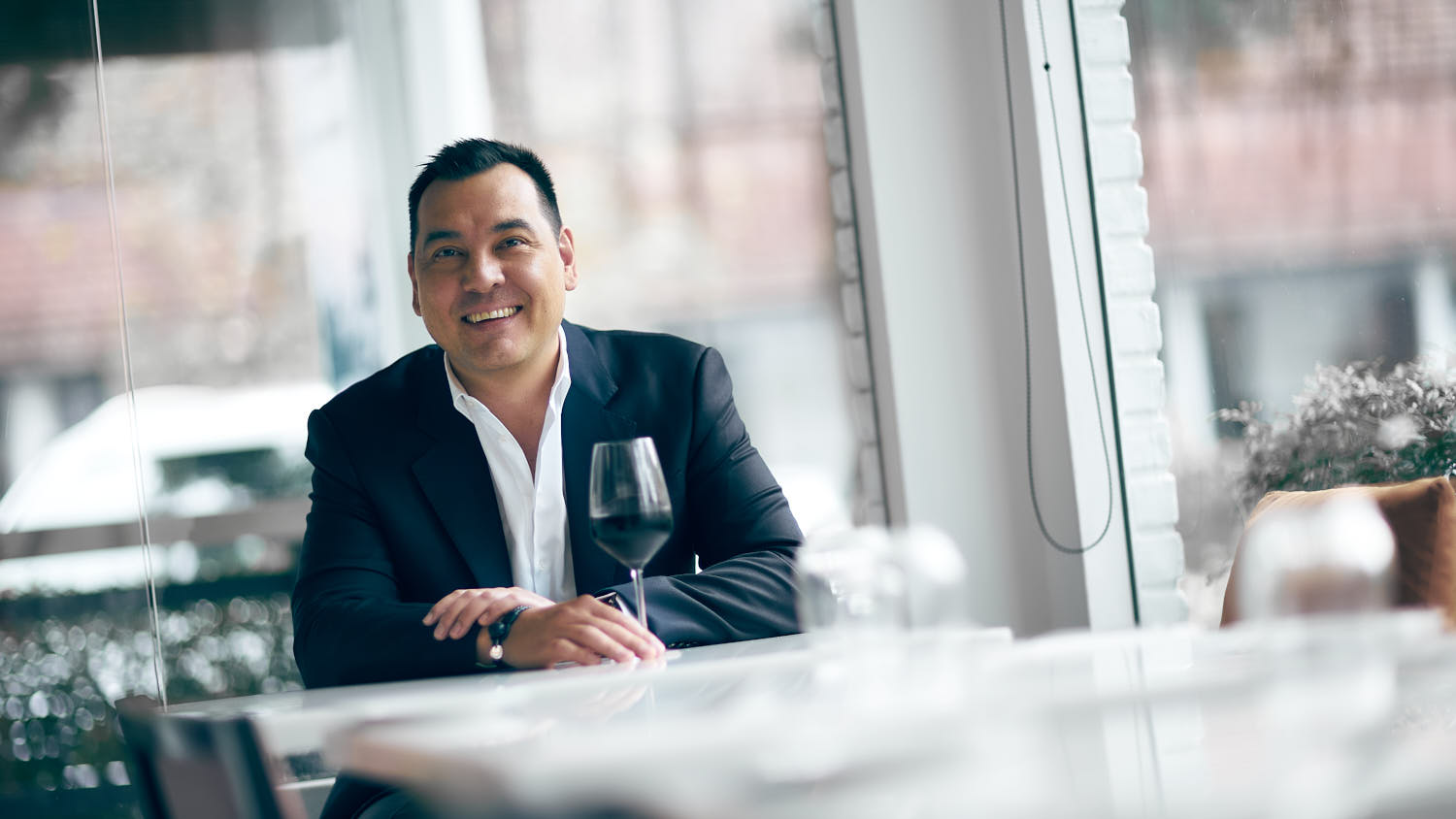 Confident executive man smiling in restaurant setting.