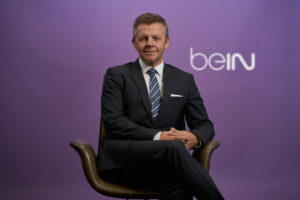 Executive in suit portrait in office environment.