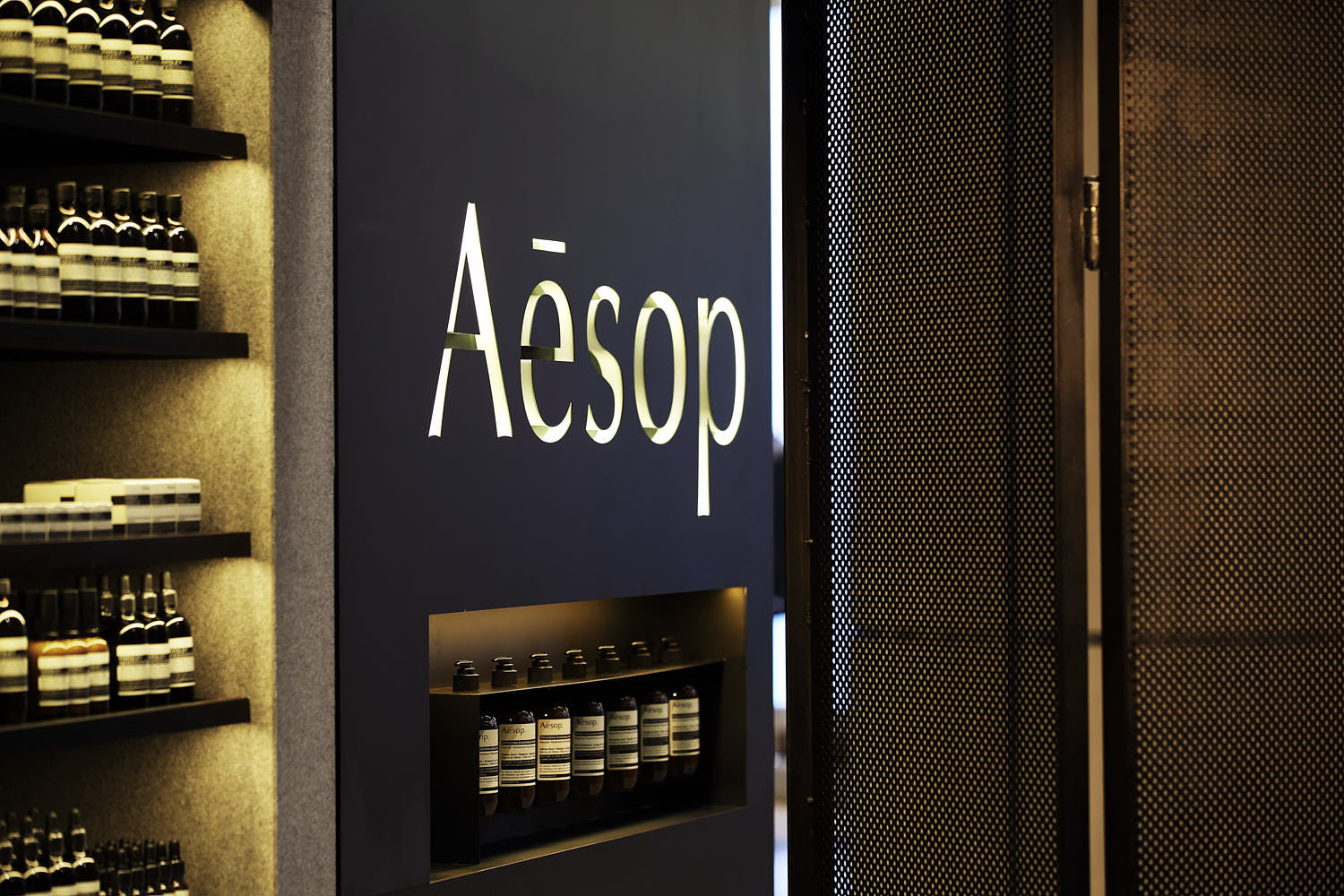 Aesop store entrance featuring raw metal elements and minimalist architectural design.