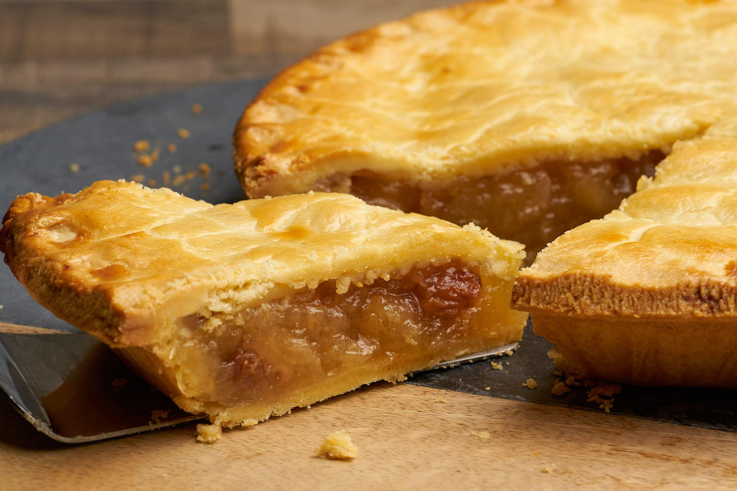 Classic apple pie with a golden lattice crust and cinnamon-spiced filling on a rustic wooden table.