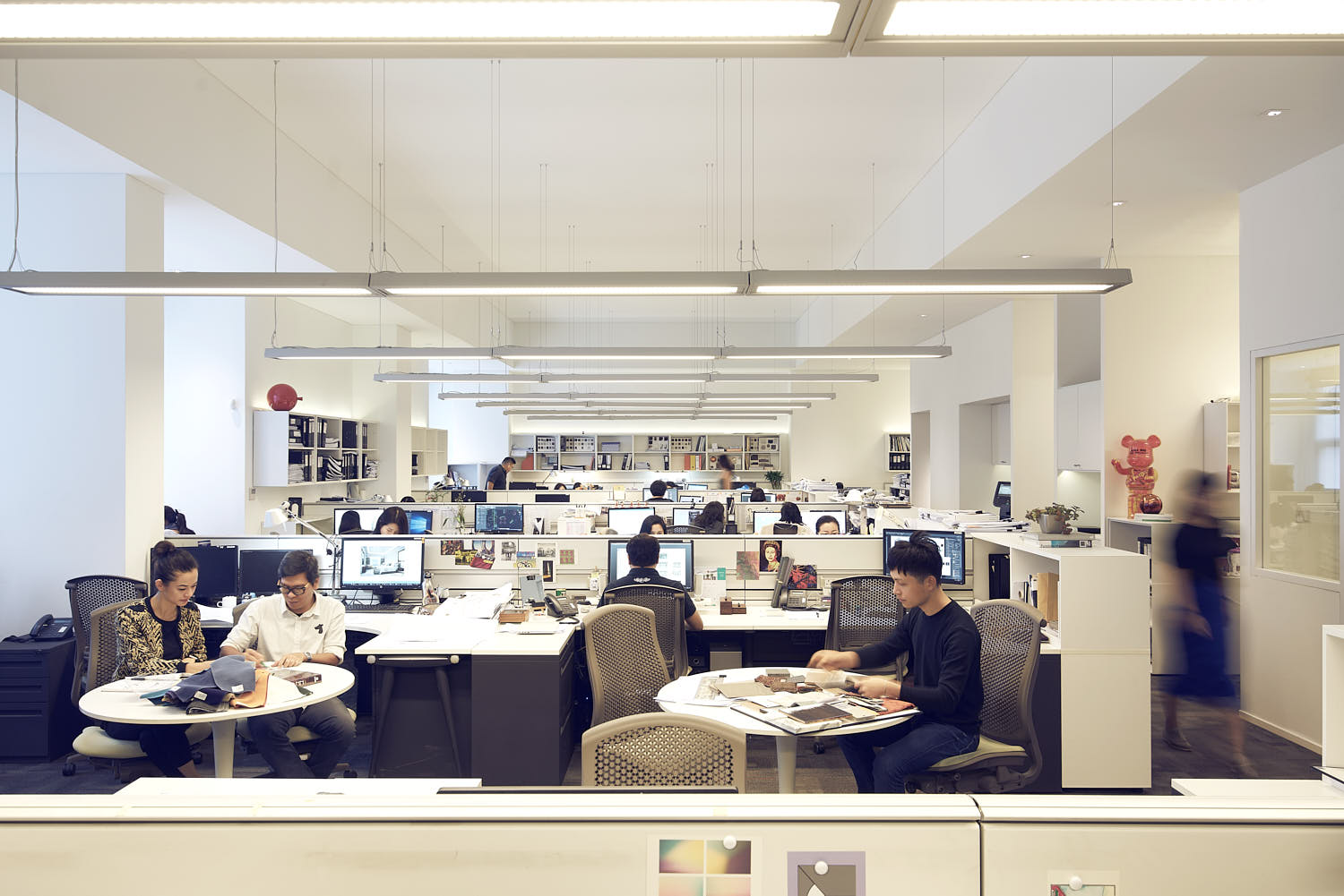Architects and designers collaborating in a busy, modern architecture office.