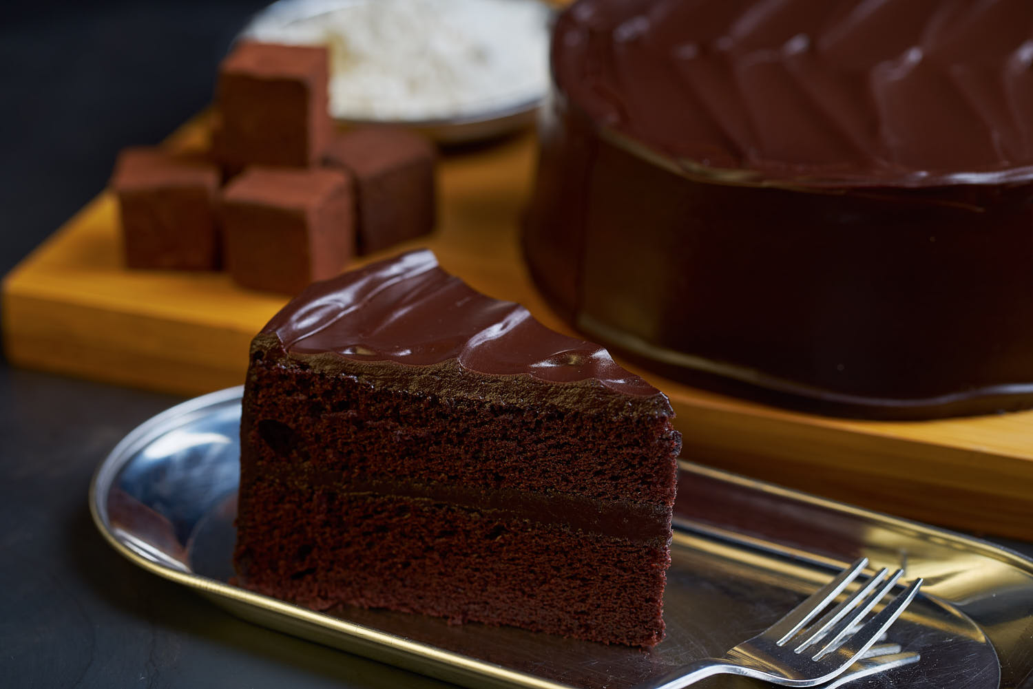 Intimate shot of a decadent cake with creamy layers and a smooth glaze from Awfully Chocolate.
