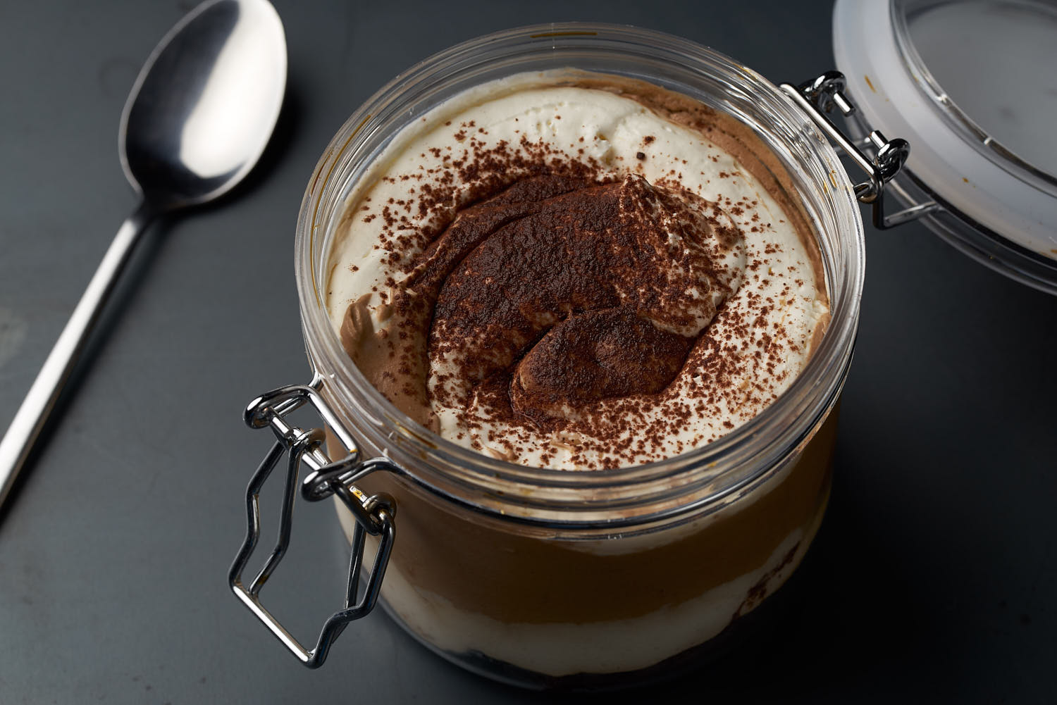 Close-up of creamy tiramisu with layers of mascarpone and a dusting of cocoa powder.