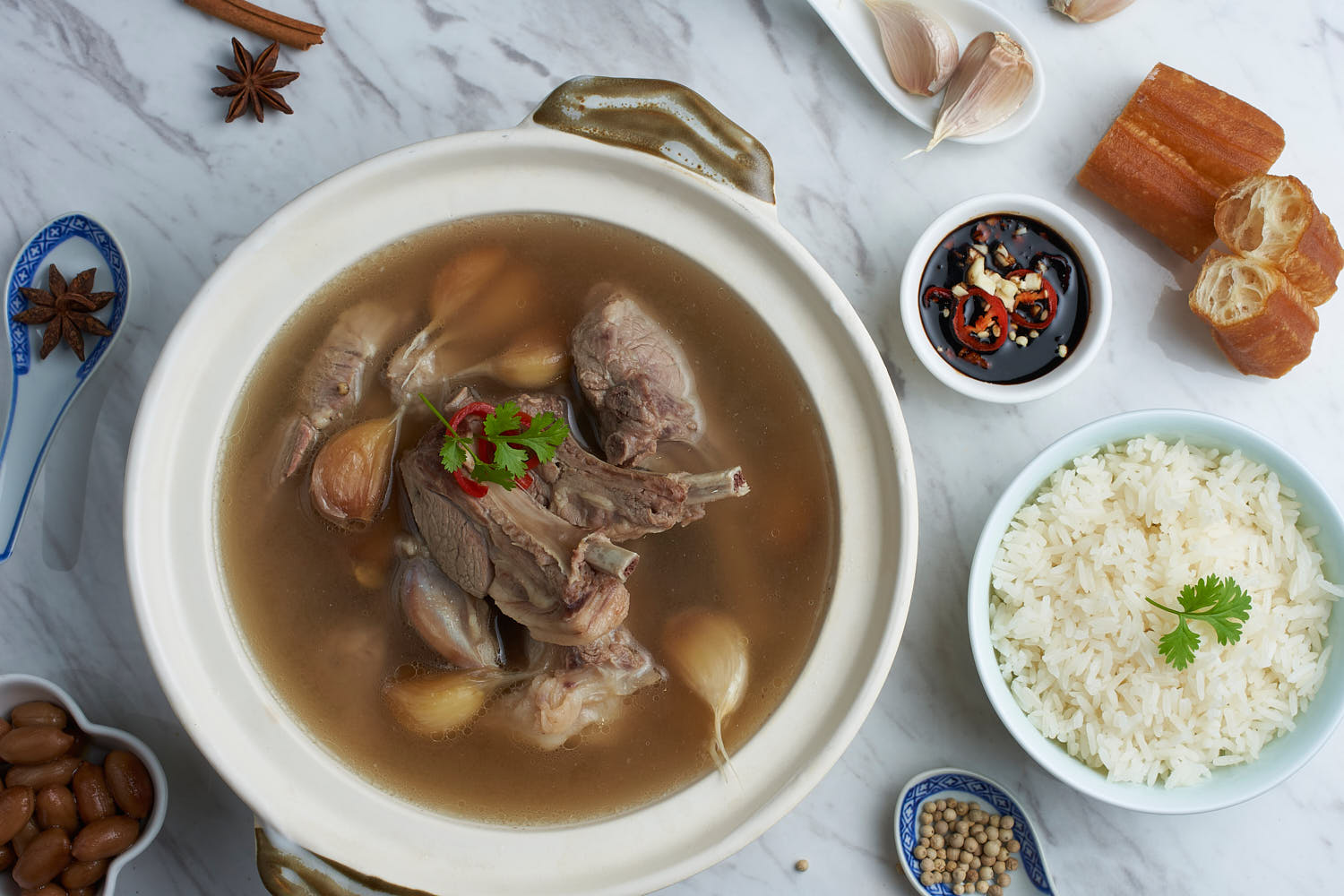 Authentic Bak Kut Teh with succulent pork ribs and a rich herbal broth, served in a clay pot.
