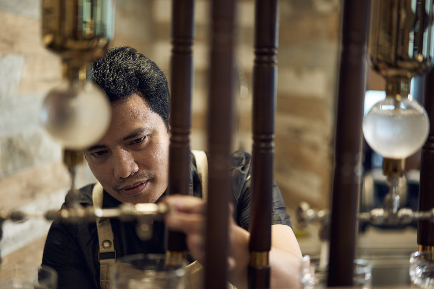 Barista expertly preparing gourmet coffee in a stylish café setting.