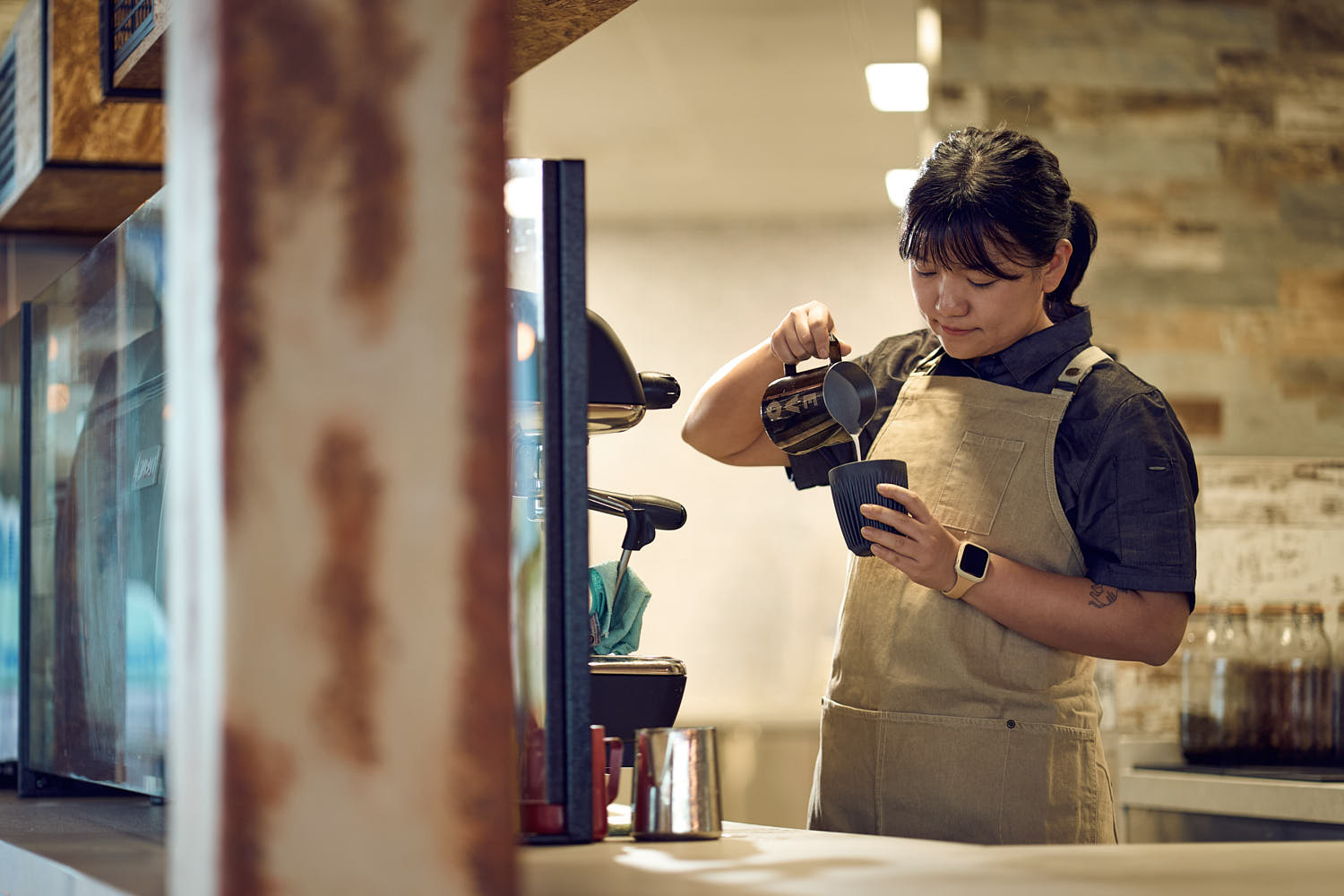Latte art served by a barista in a warm and inviting café atmosphere.