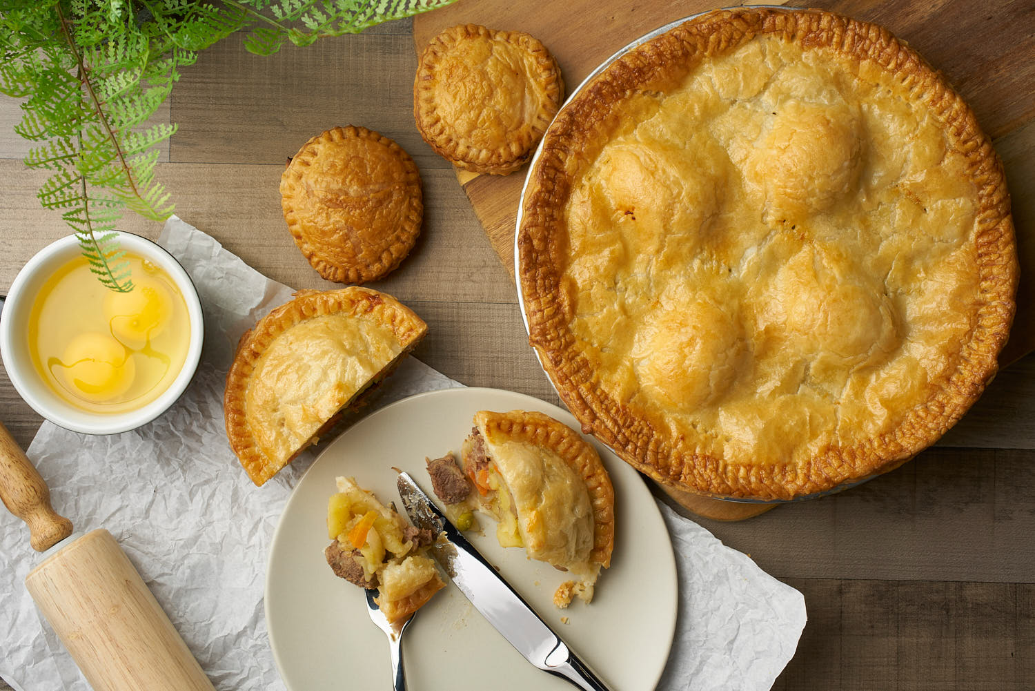 Golden brown beef pot pie with flaky crust served in a rustic dish.