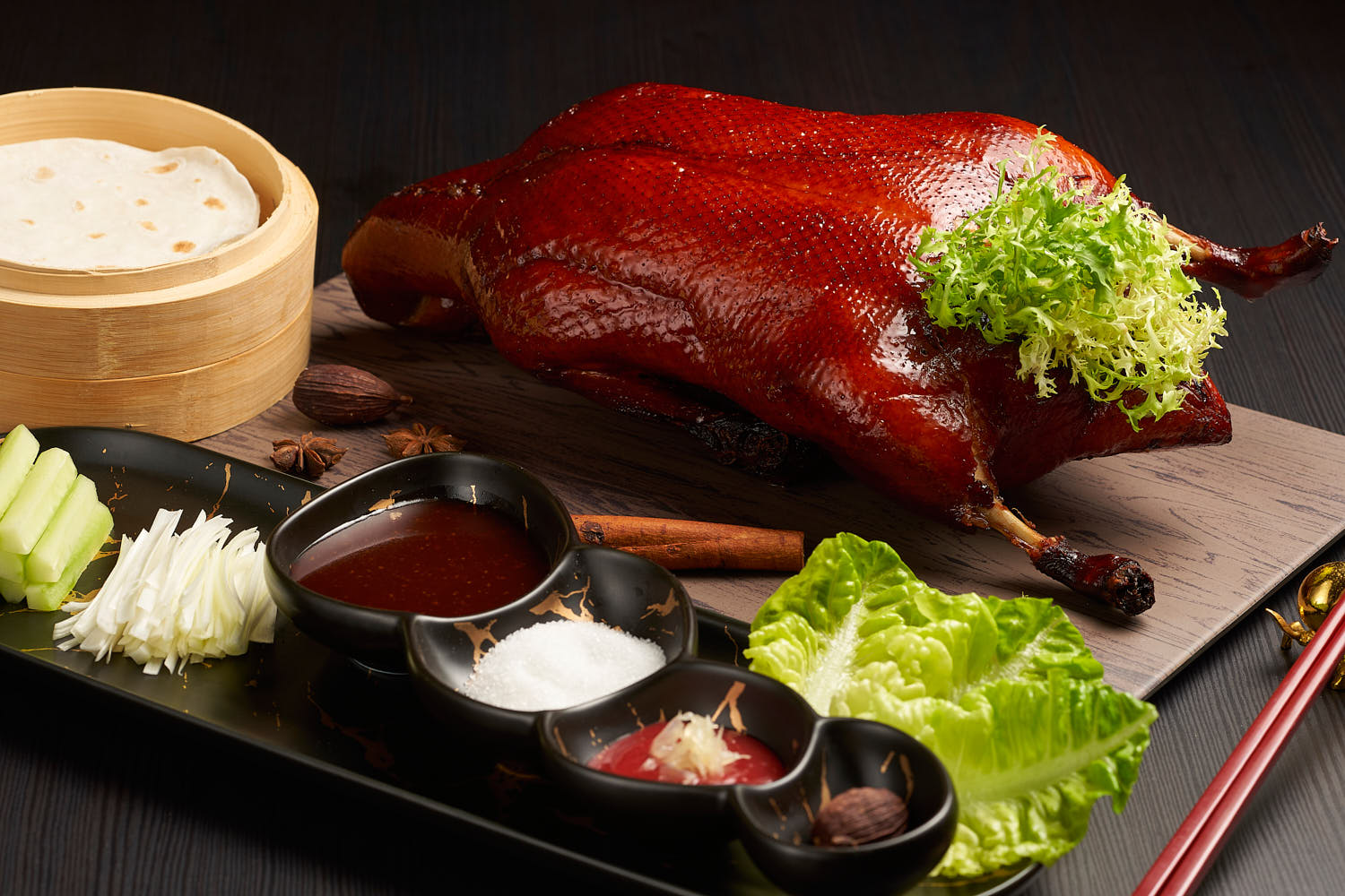Crispy Peking duck with thin crepes, hoisin sauce, and sliced scallions.