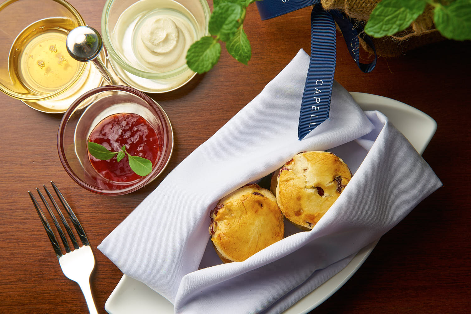Freshly baked golden scones arranged with whipped cream and a side of berry compote.