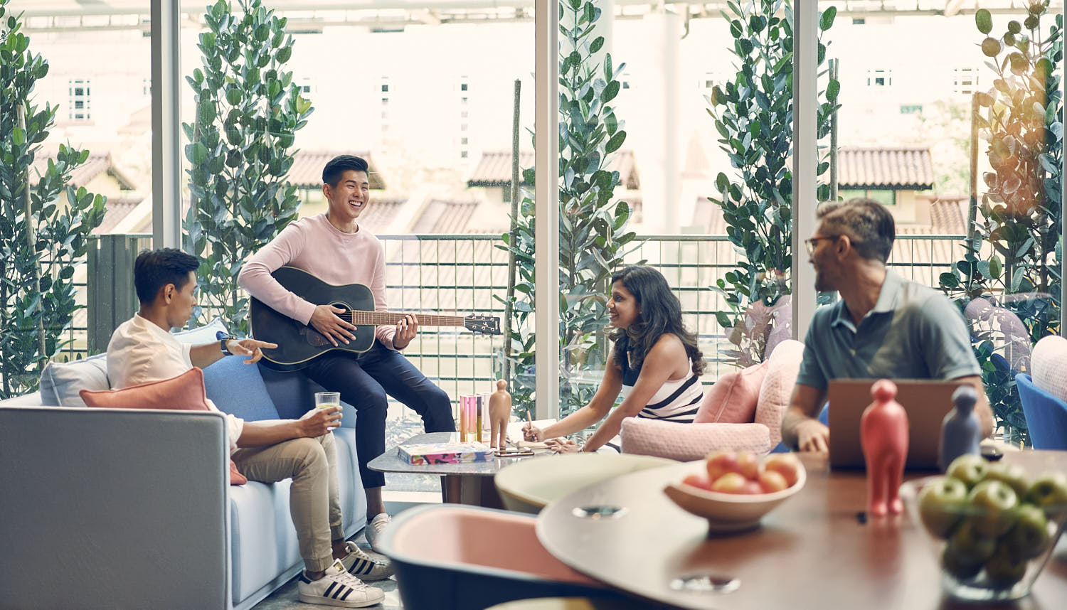 Friends laughing and enjoying a casual brunch together on a café patio.