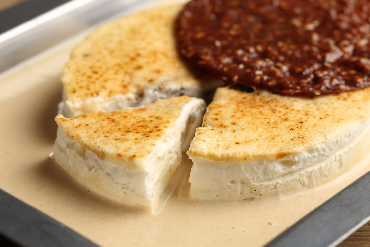 Close-up of delicate chocolate pralines on a creamy dessert base with vanilla drizzle.
