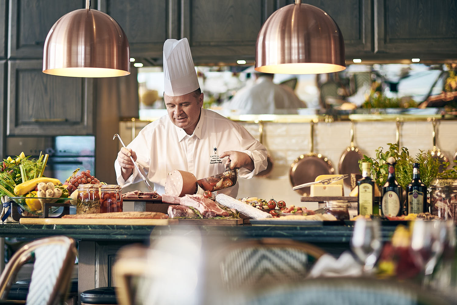 Chef preparing a gourmet meal at Capella Singapore Chef's Table private dining.