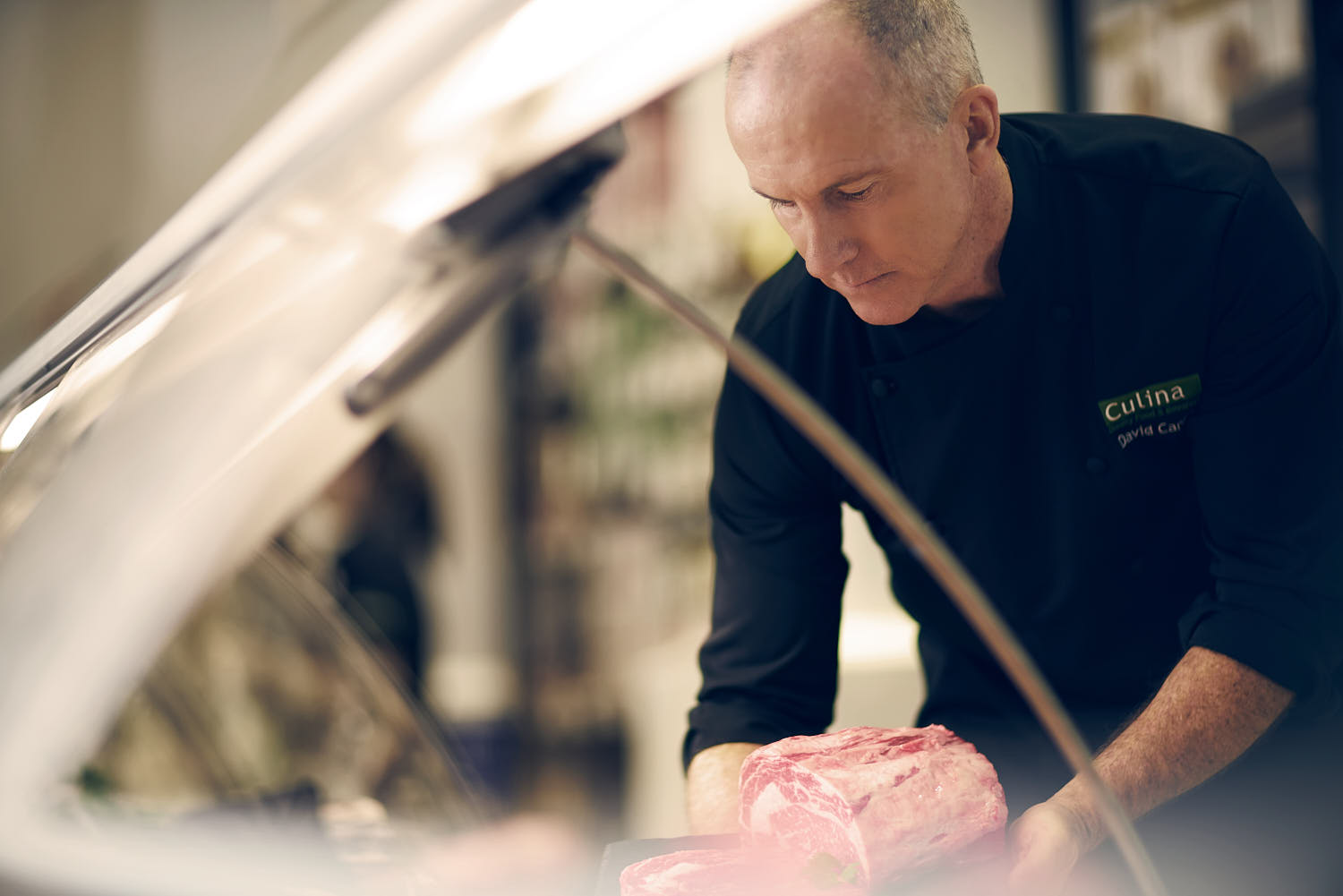 Chef carefully selecting premium cuts of meat in a gourmet kitchen.