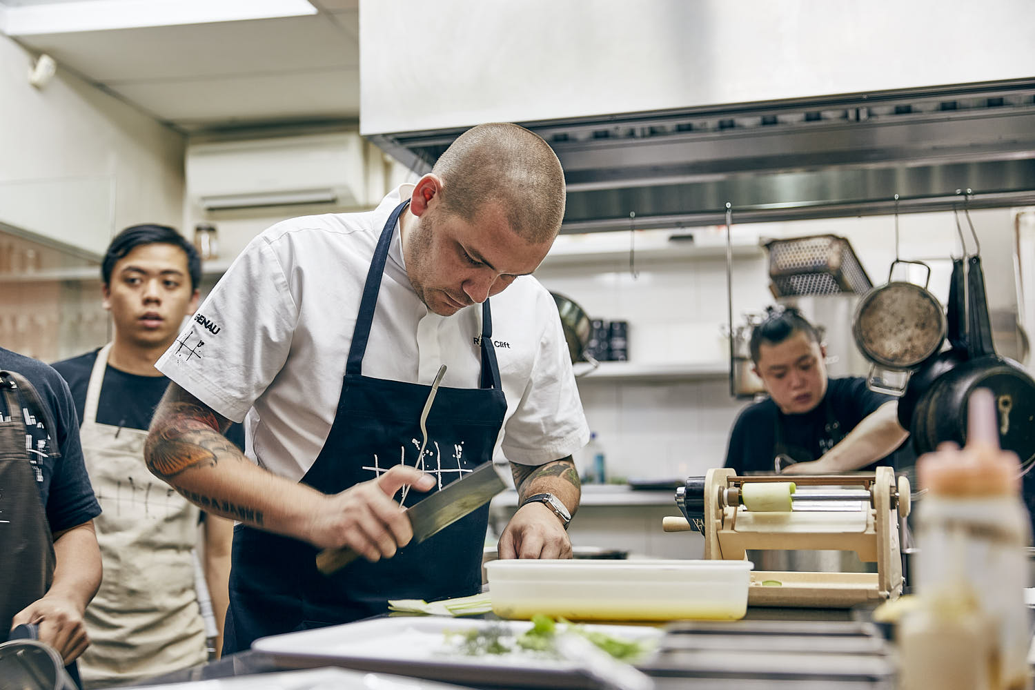 Chef preparing a gourmet dish in an open kitchen, showcasing culinary skills.