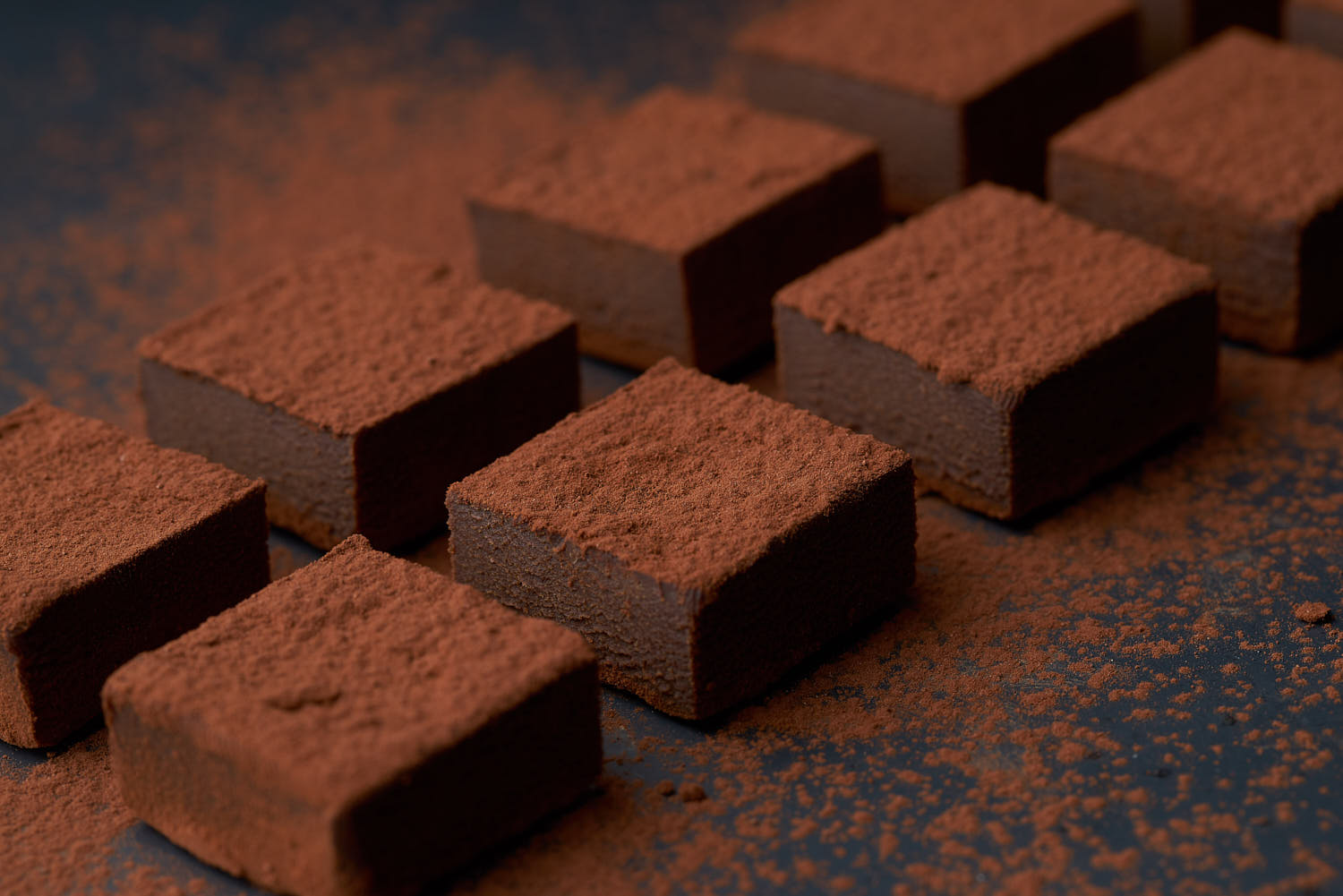 Dark chocolate truffles on a rustic board with cocoa powder dusting.
