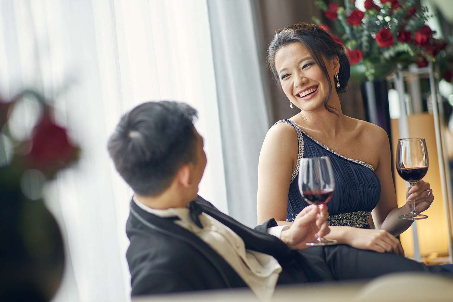 Romantic couple enjoying wine together in a chic hotel suite.