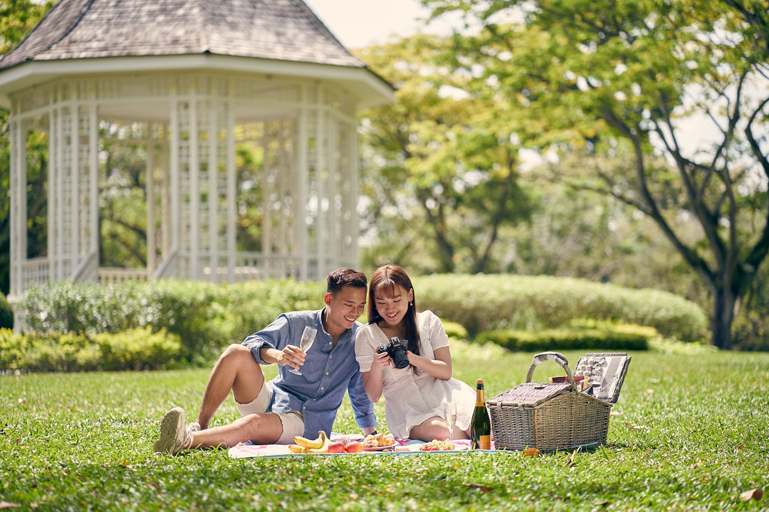Couple enjoying a relaxing picnic together in a beautiful garden setting.