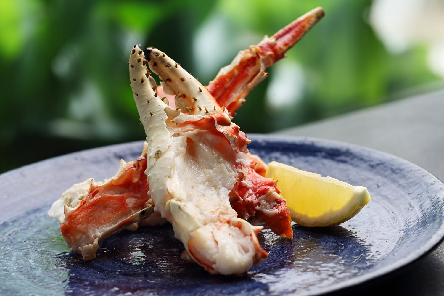 Delicious crab claw with cracked shell, garnished with lemon.