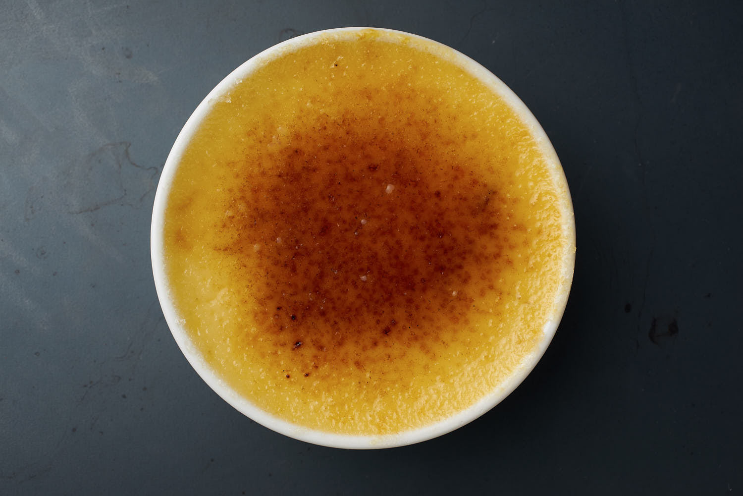 Top-down view of a crème brûlée with a perfectly caramelized golden sugar crust.