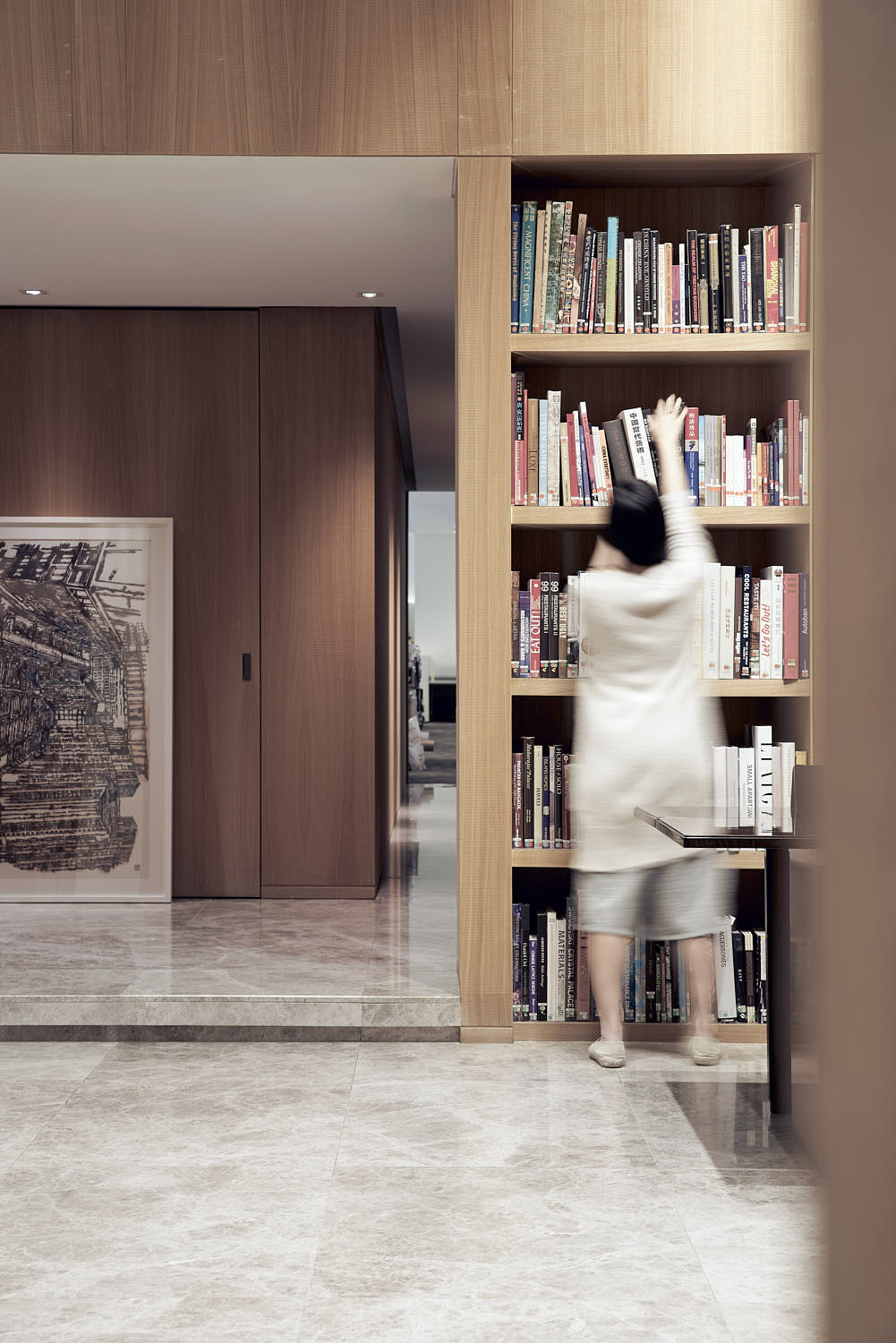 Designer browsing through books in a library for inspiration and design ideas.