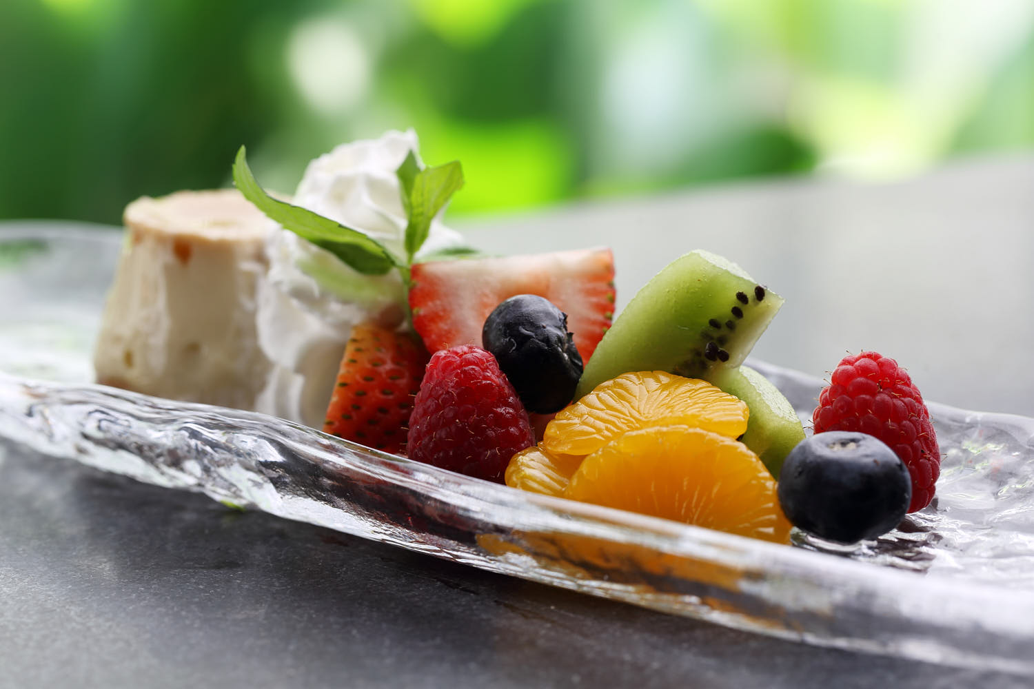 Fruit platter served with pudding and cream.