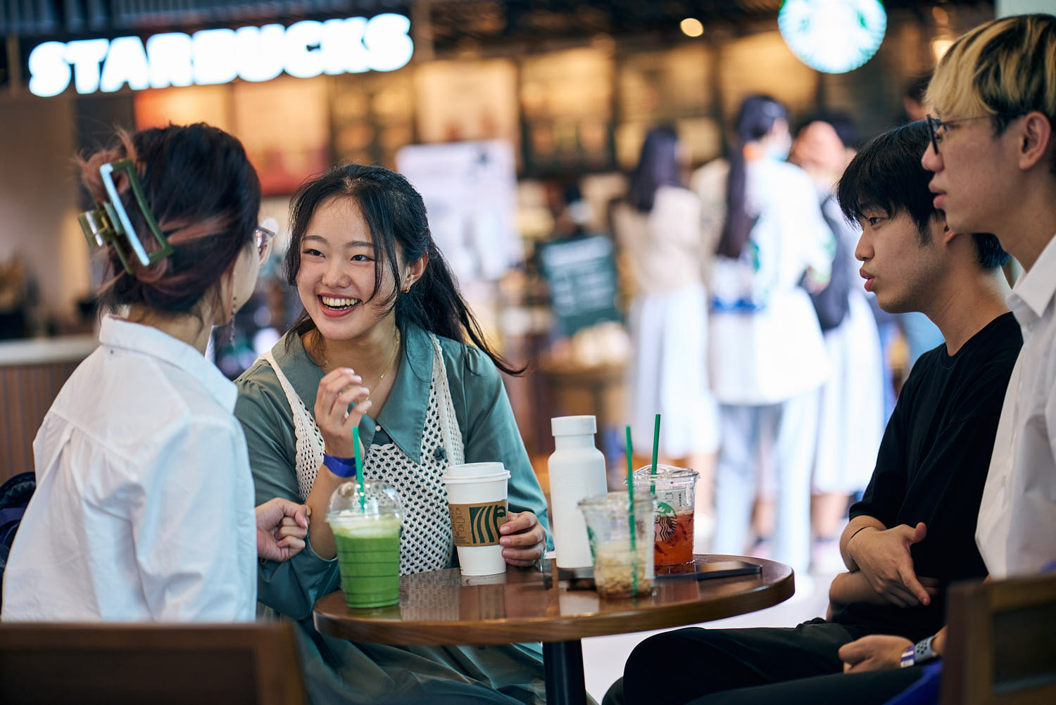 Group of university students studying in a campus café, collaborating on projects.