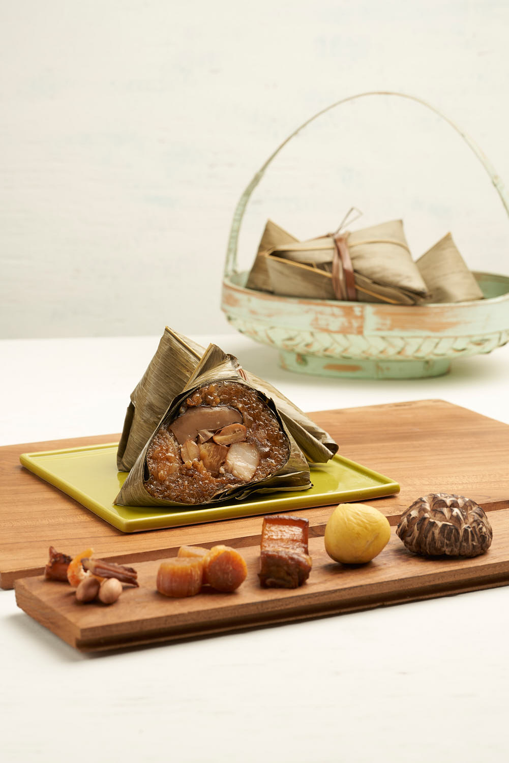 Festive glutinous rice dumpling filled with savory mushrooms, dried scallops, and tender pork, wrapped in a bamboo leaf.