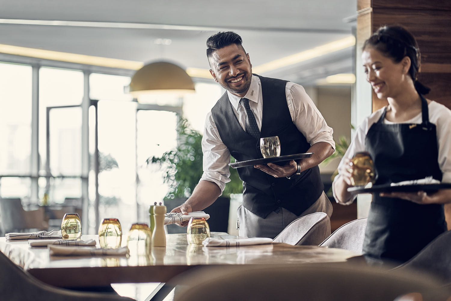 Server carefully setting the table for an elegant fine dining experience.