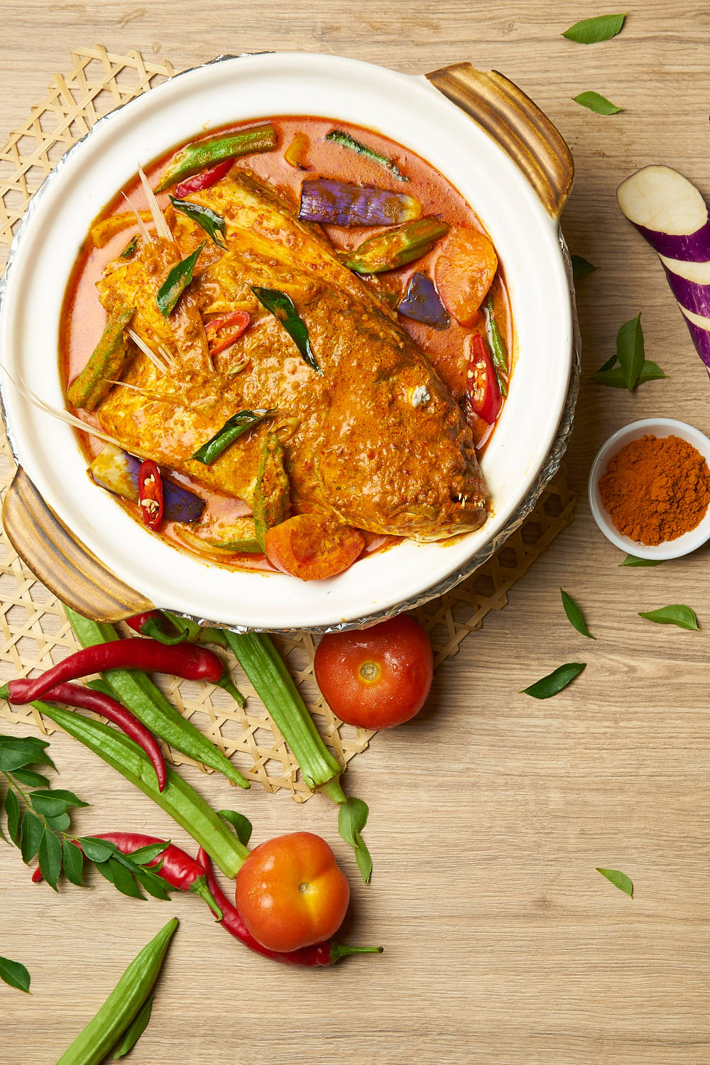 Traditional curry fish head cooked to perfection garnished with lady fingers and tomatoes.