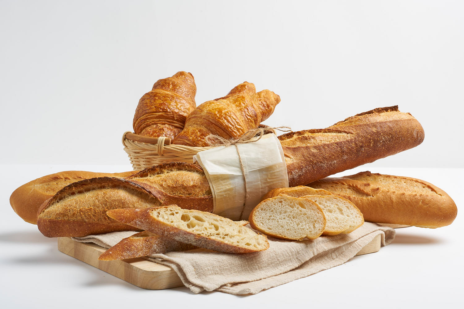 Assorted French bakery treats including croissants and baguettes displayed on a rustic wooden board.