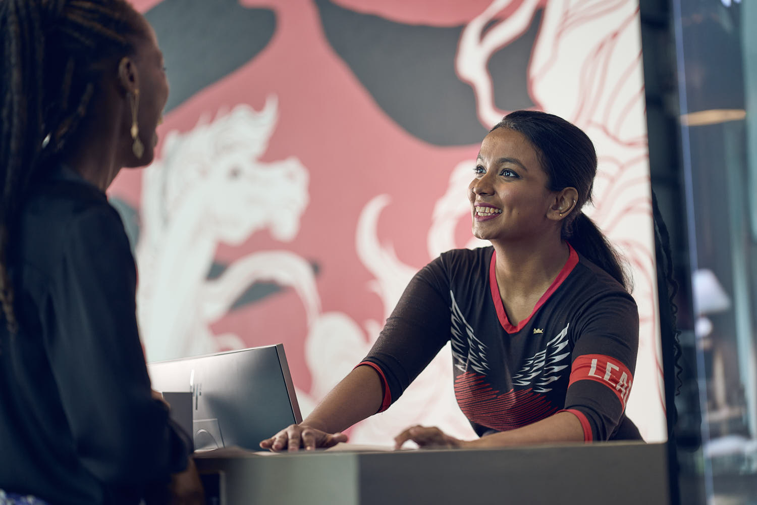 Front desk agent providing room details and information to a hotel guest.