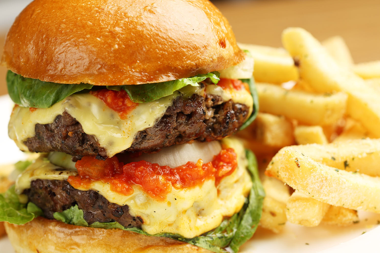 Juicy indulgent beef burger with melted cheese, and fresh toppings, served in a toasted bun.