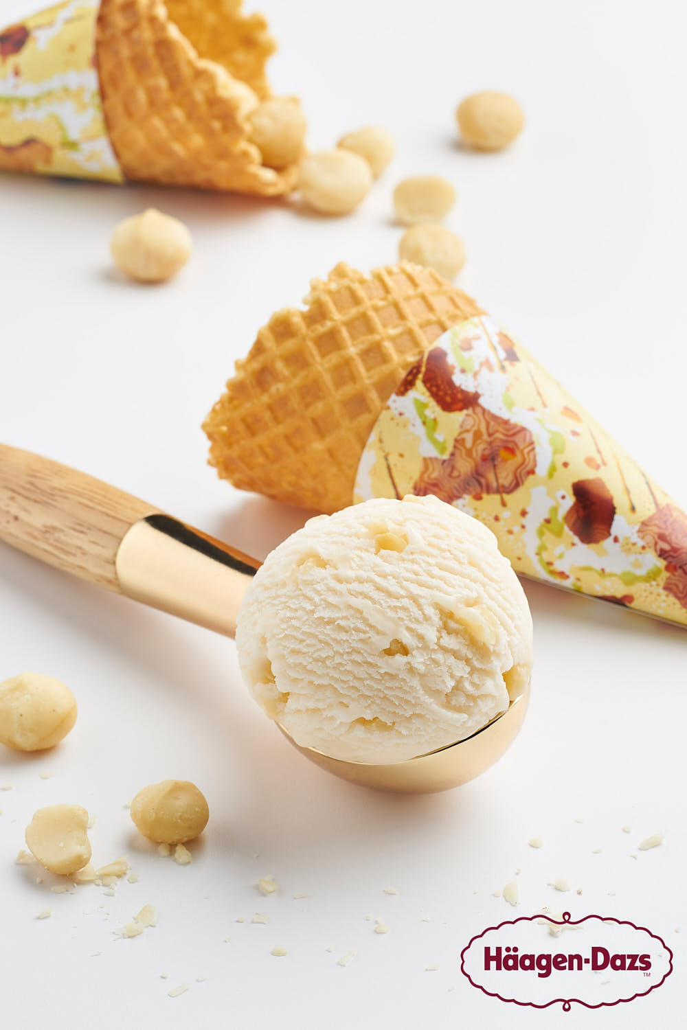 Häagen-Dazs macadamia nut ice cream scoop in a waffle cone, topped with crushed macadamia nuts.