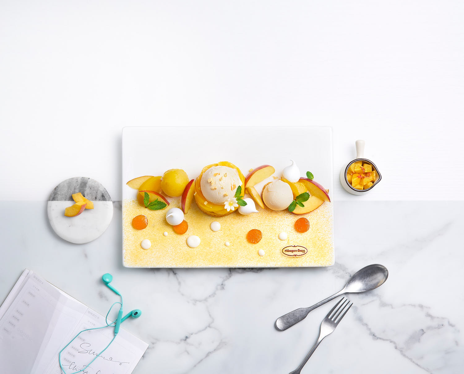 Artistic lifestyle shot of peach and mango flavours, styled with fresh mint, peach slices, and a hint of sugar crystals.