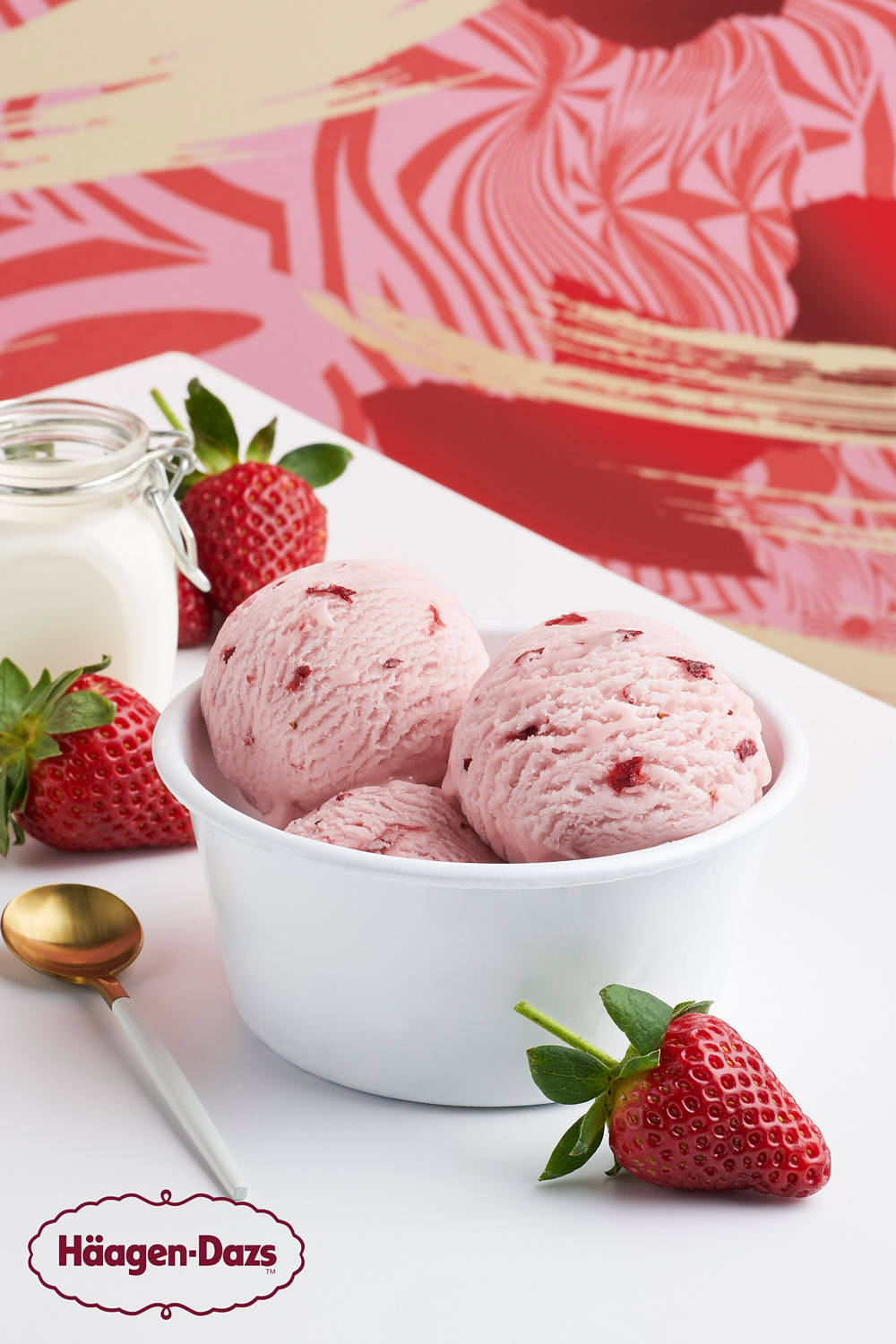 Bold pink strawberry ice cream in a white bowl.