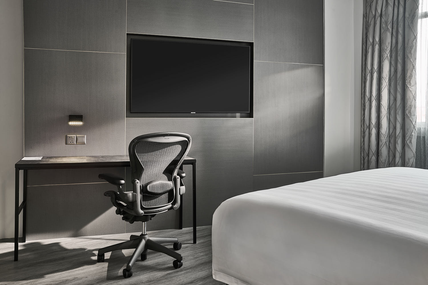 Hotel room study table lit by a streak of natural sunlight.