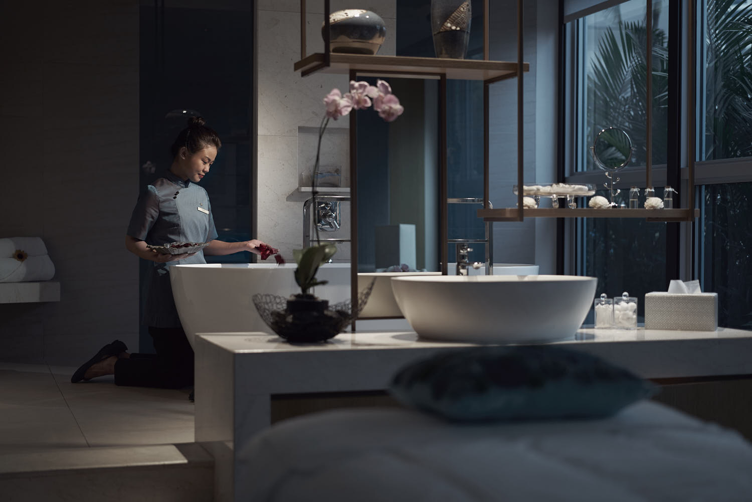 Therapist preparing a calming hotel spa room for a rejuvenating experience.