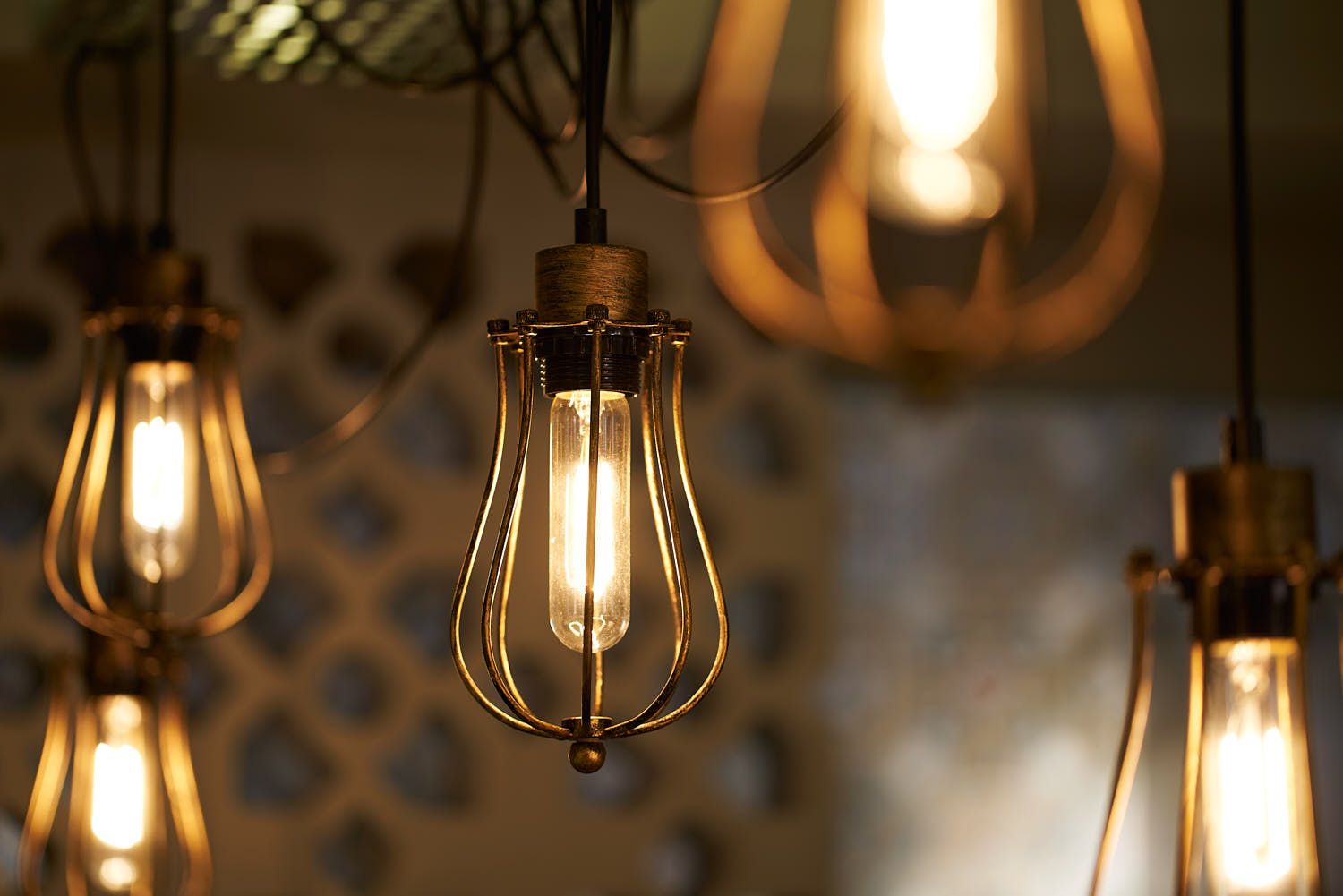 Close-up of industrial lights with brass fittings in a warm-toned interior setting.