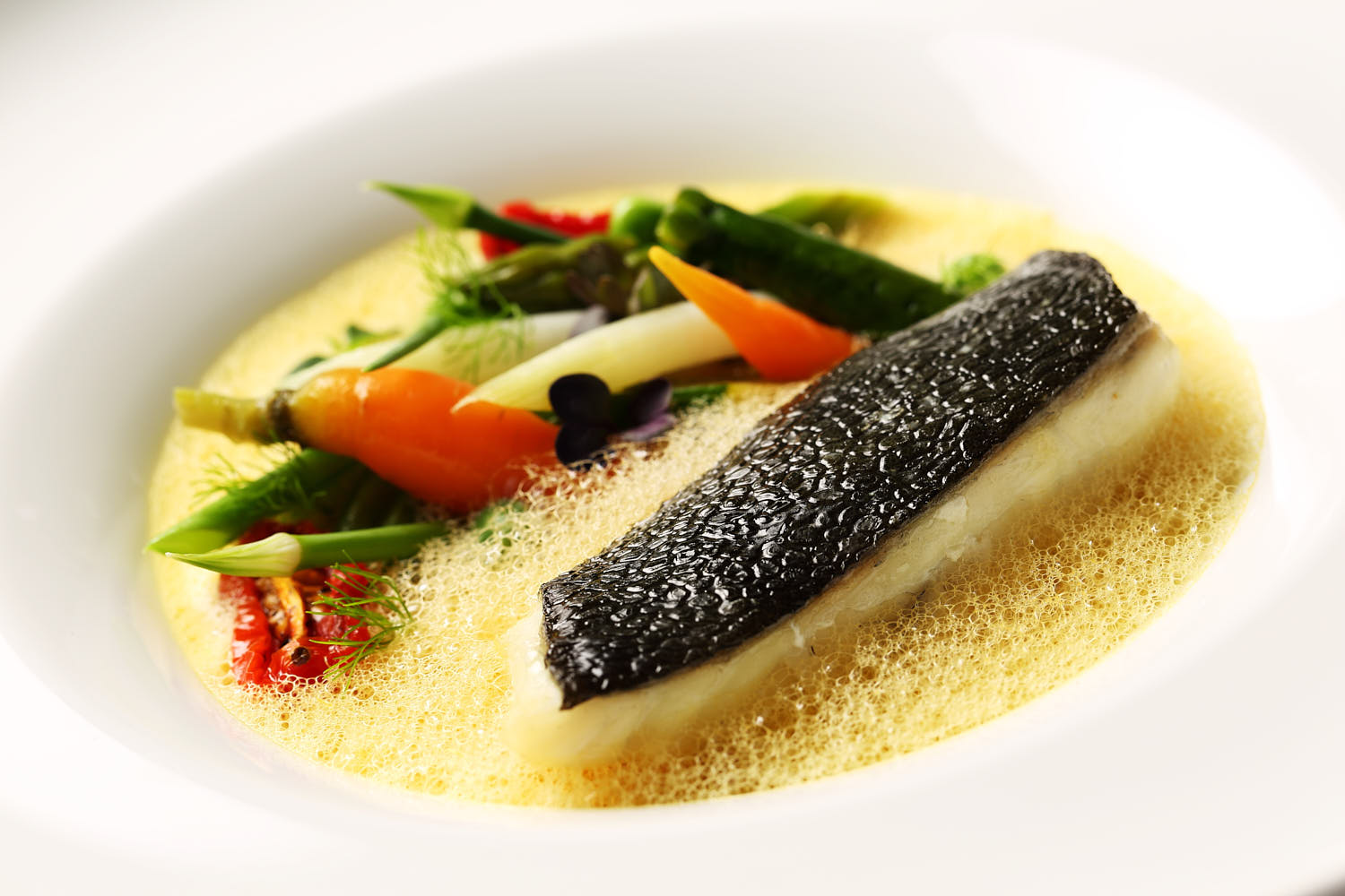 Baked Italian fish in a creamy white wine and lemon sauce, garnished with roasted garlic and thyme.