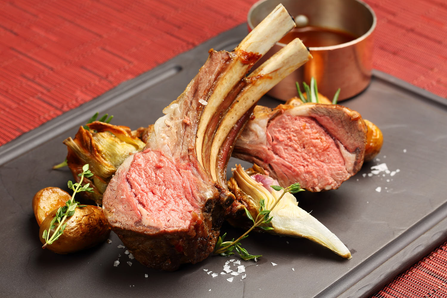 Medium rare lamb chop sprinkled with sea salt.